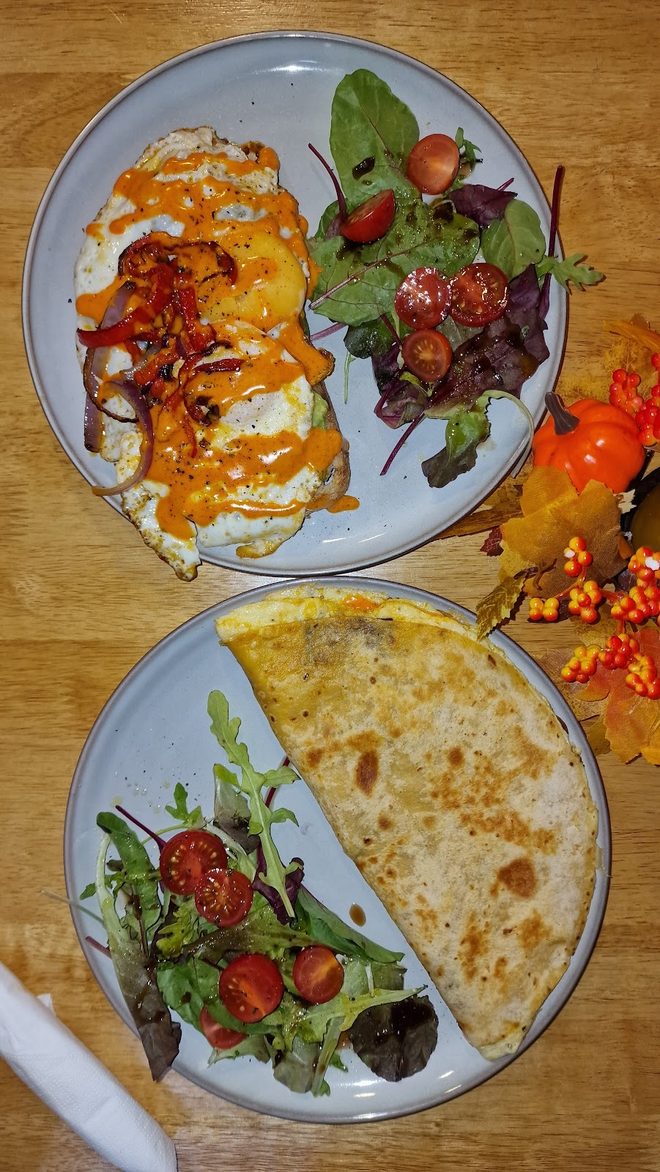 Two plates shared across a table: eggs with chilli sauce, and a quesadilla