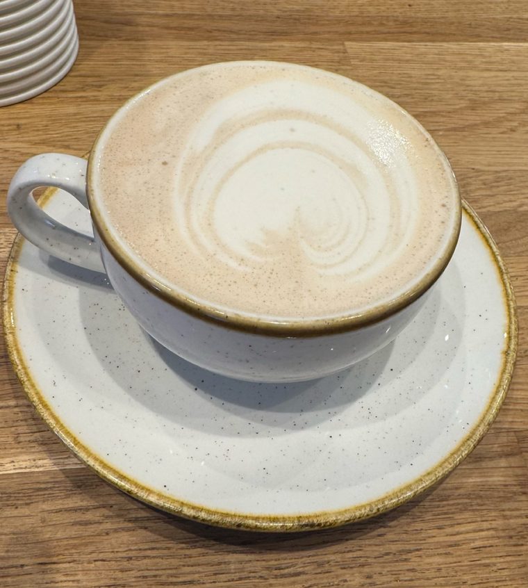 A flat white in a speckled ceramic cup and saucer