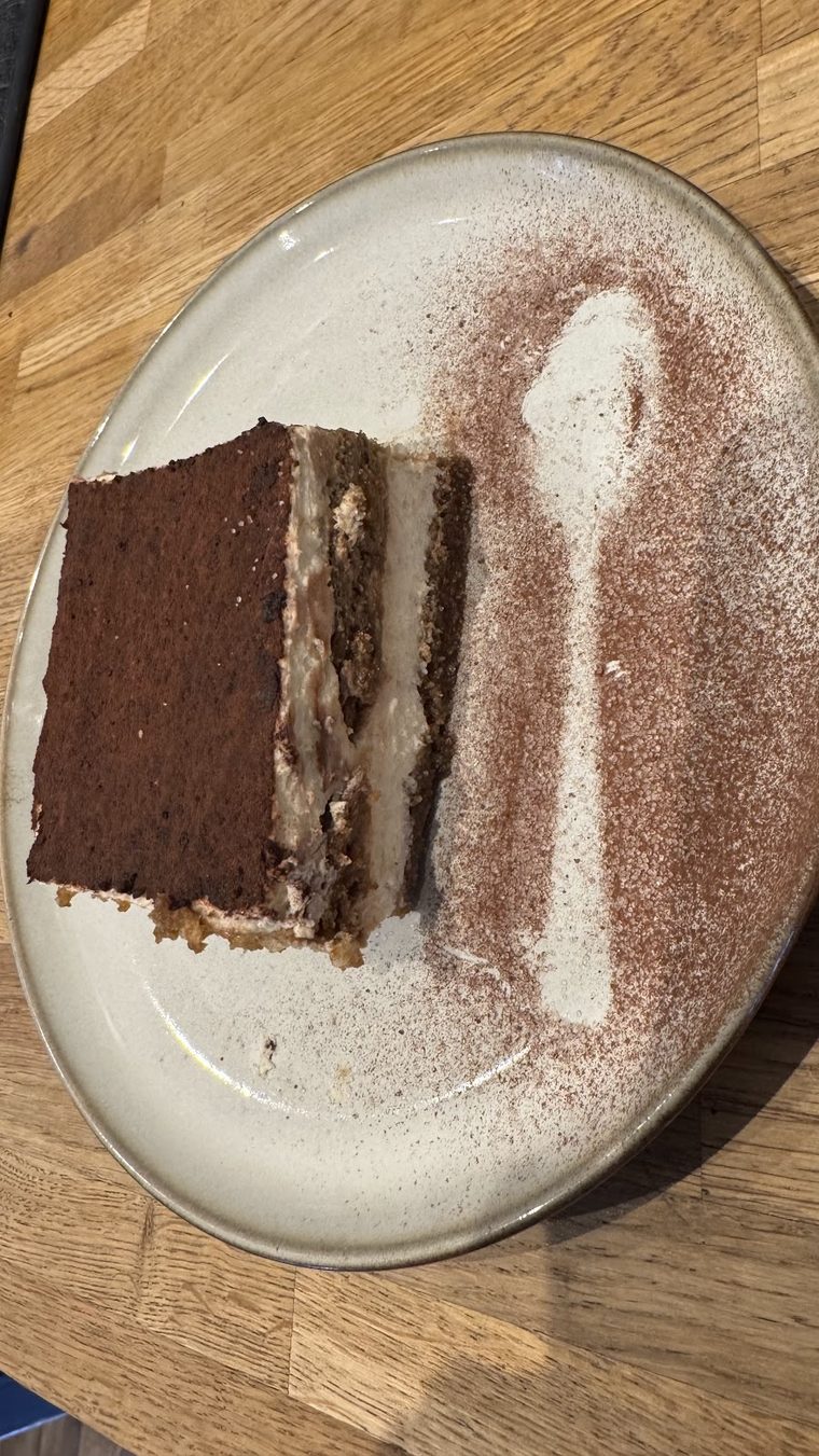 A slice of chocolate cake dusted with cocoa
